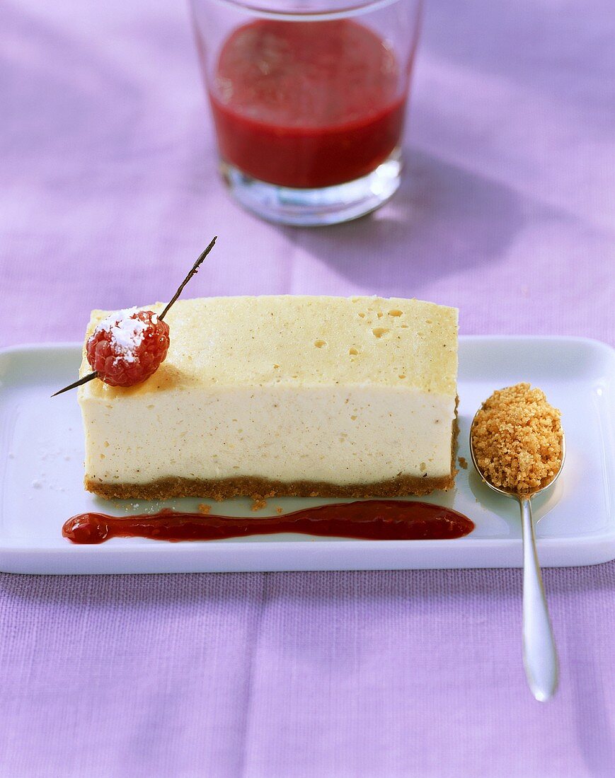 A piece of cheesecake with raspberries & raspberry sauce