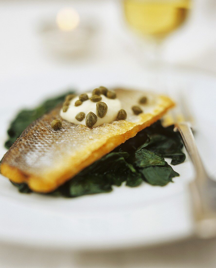 Pike-perch with capers on spinach