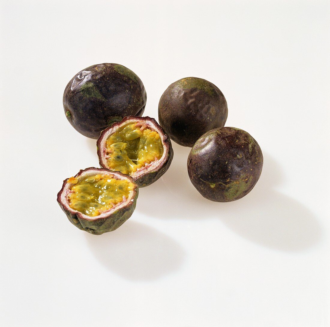 Maracuyas, whole and halved (purple granadilla)