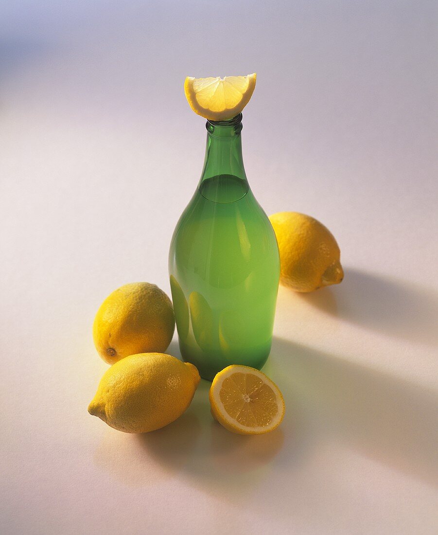 Eine Flasche Zitronenessig und Zitronen