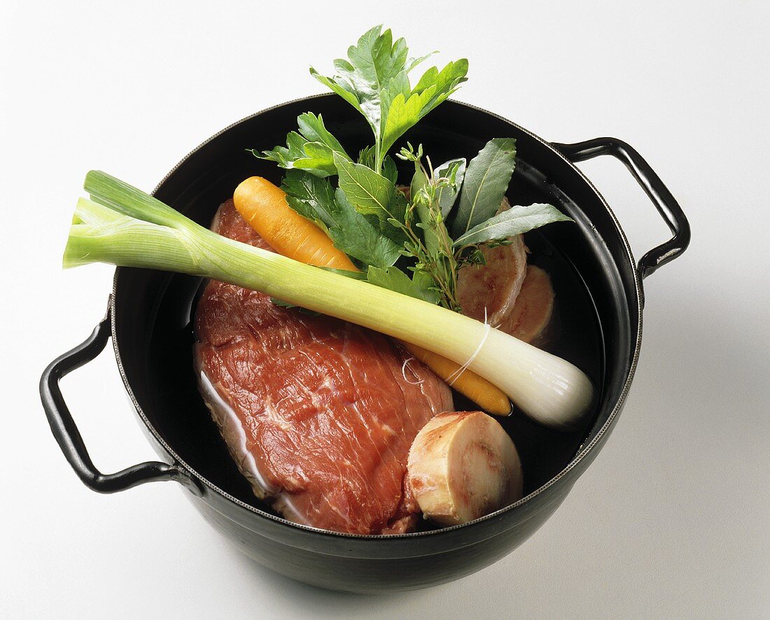 Ingredients for beef soup in a pot