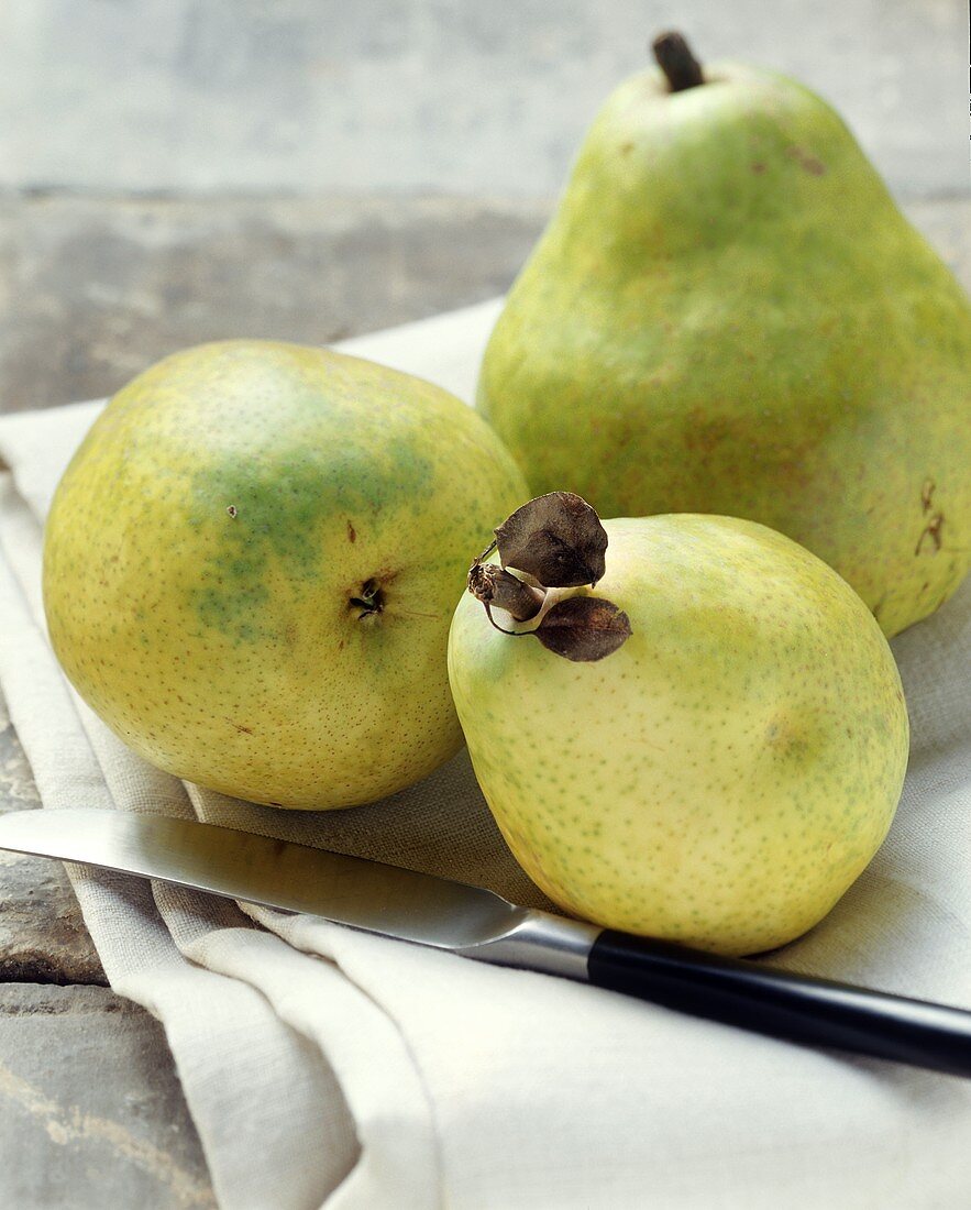 Three yellow pears and a knife