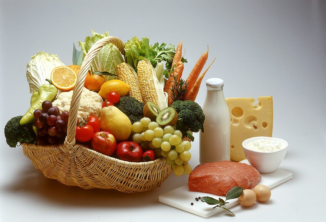 Basket of fruit & vegetables, veal & dairy products beside it