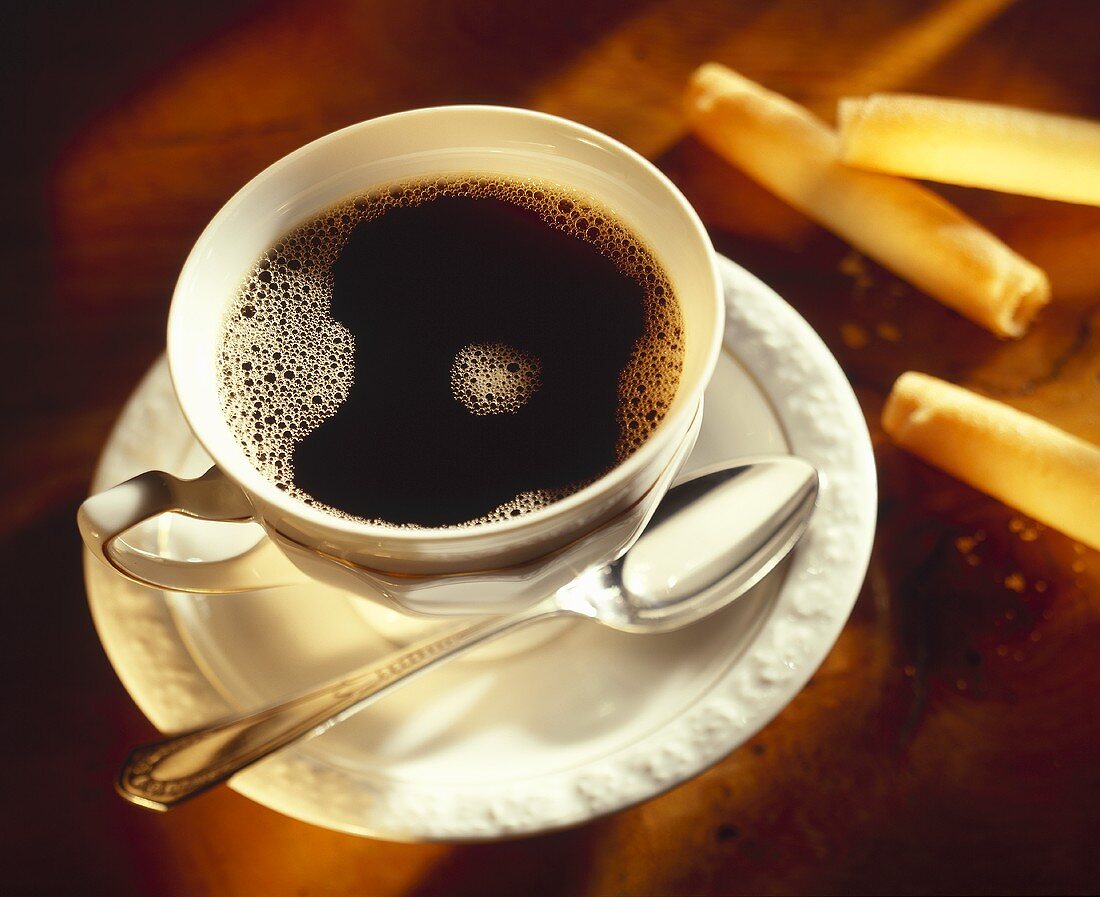 Eine Tasse Kaffee und Hippenröllchen