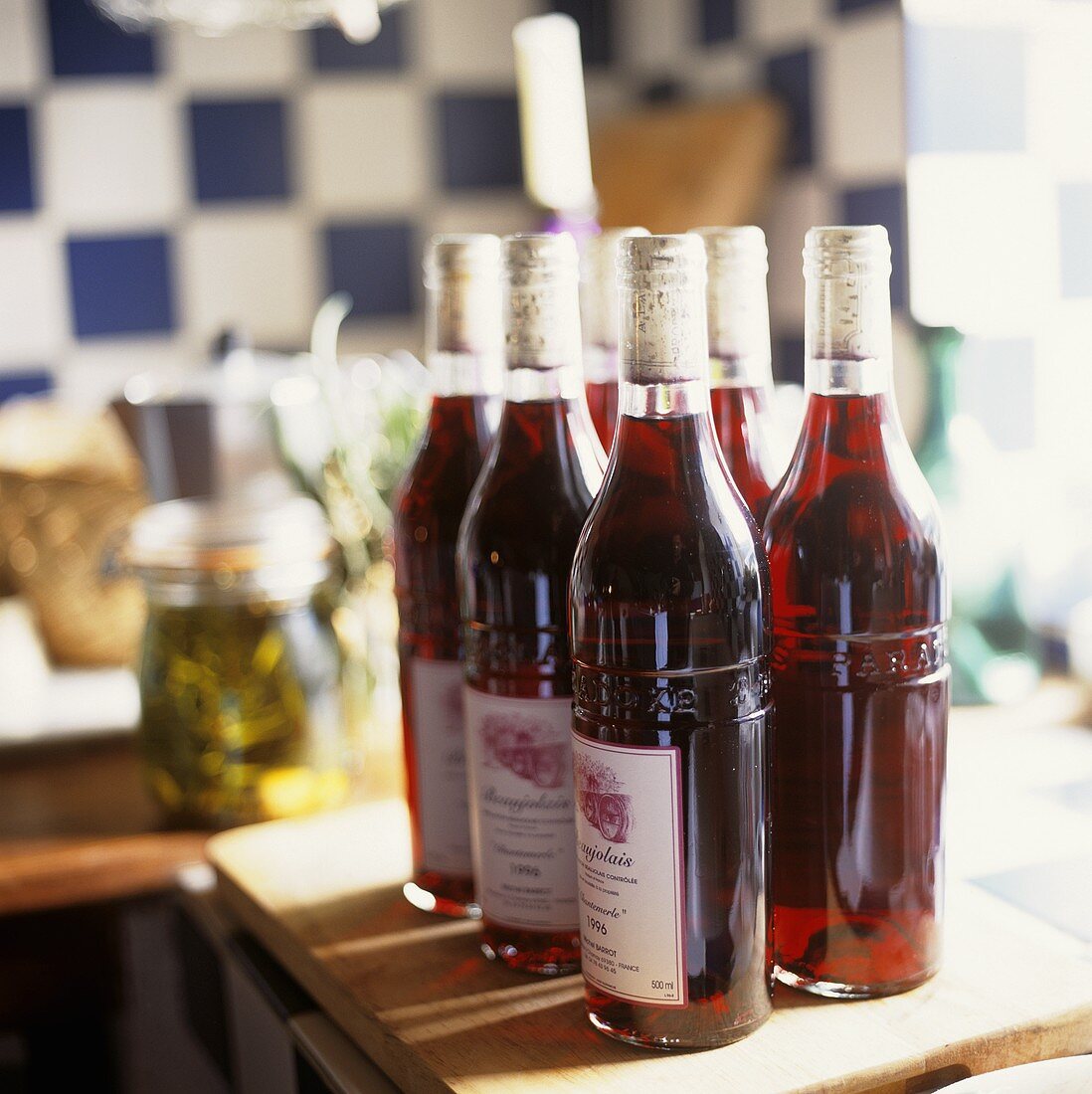 Several bottles of red wine in a kitchen