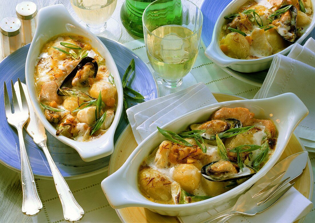 Three portions of fish gratin with spring onions and mussels