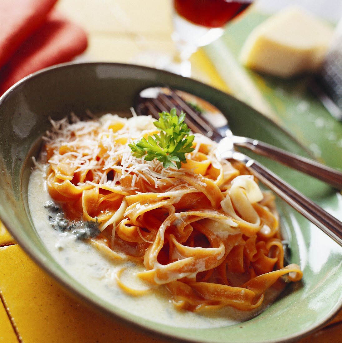 Tomato tagliatelle in cheese sauce, sprinkled with Parmesan