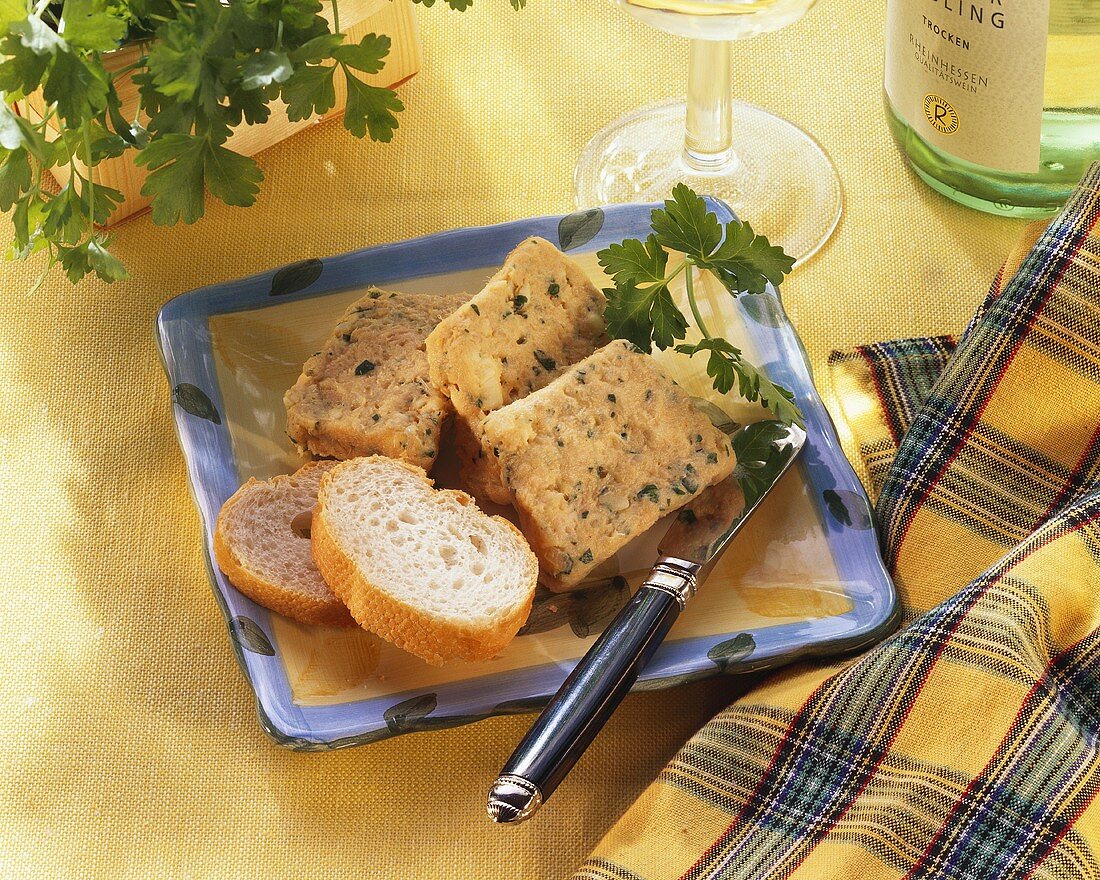 Terrine von geräuchertem Saibling mit Brot auf Teller