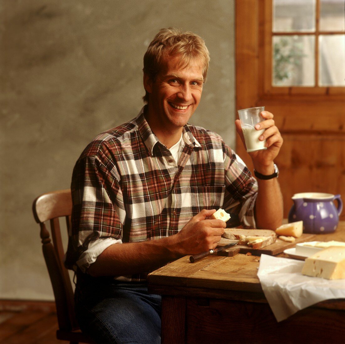 Mann beim Frühstück mit Käse und Milch
