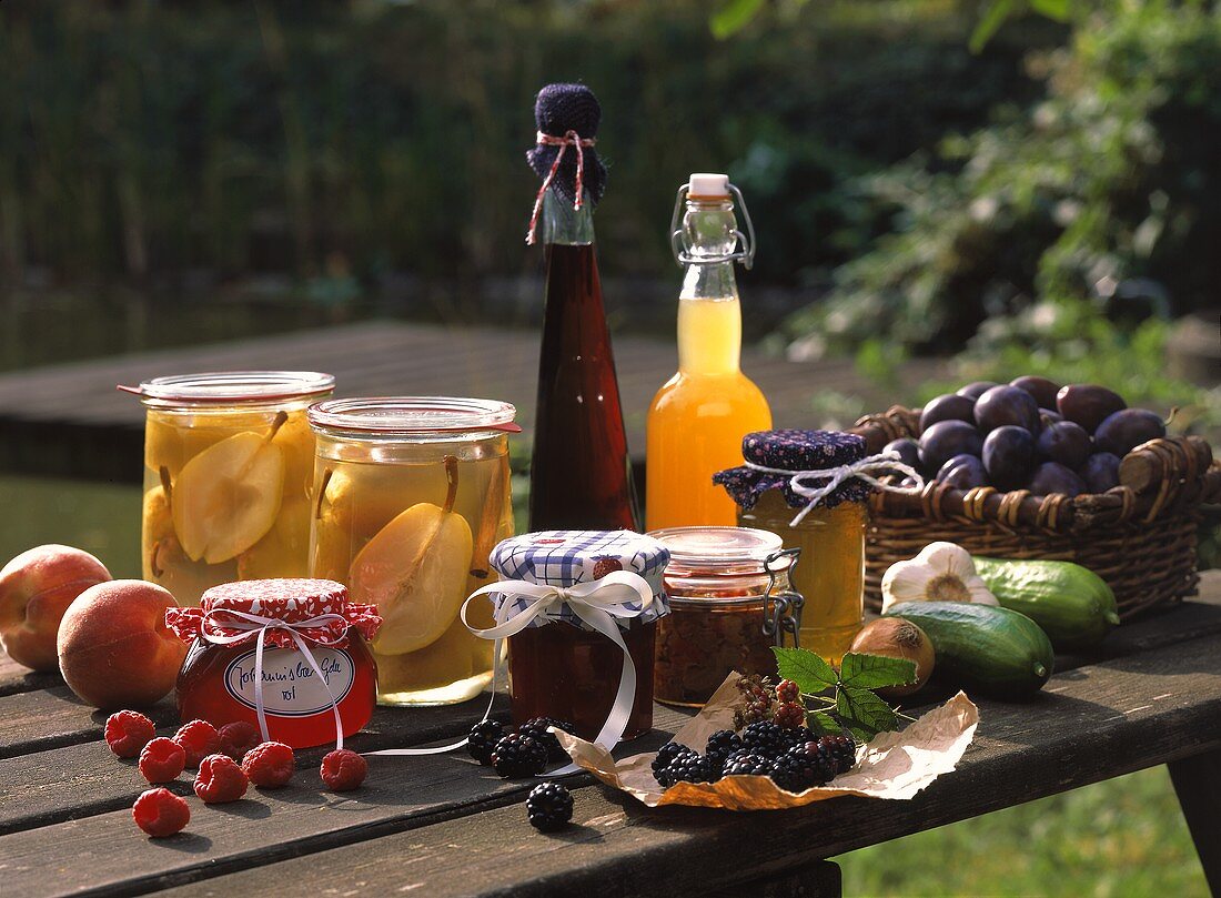 Stillleben mit eingemachtem Obst, Gelee, Likör und Saft