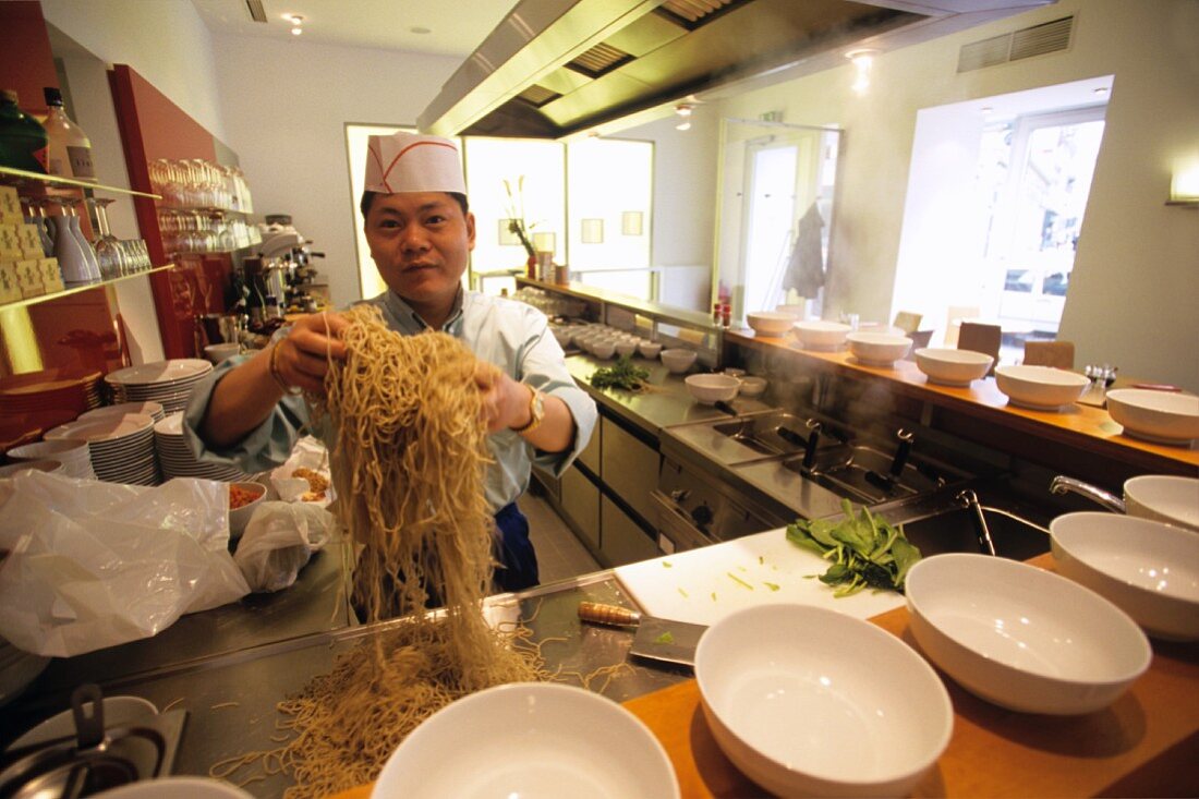 Malaysian chef preparing noodles in the kitchen