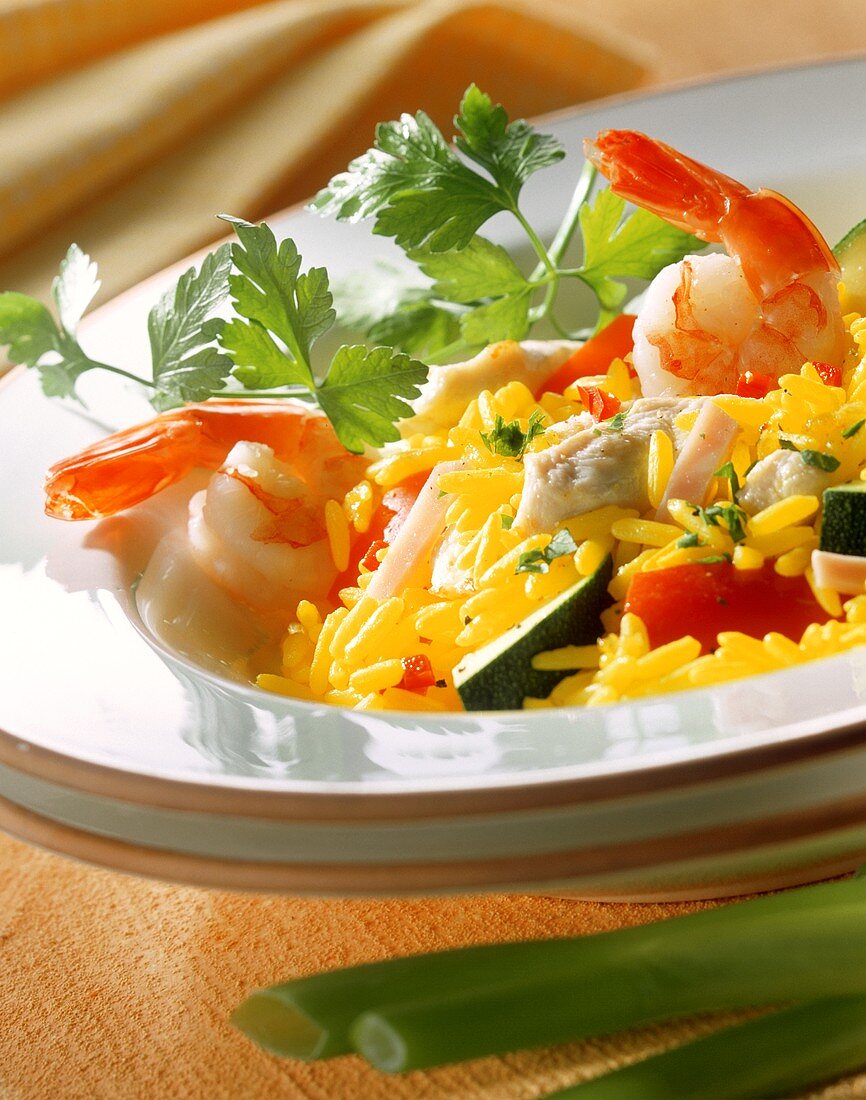 Bunte Paella mit Meeresfrüchten, Gemüse und Schinkenstreifen