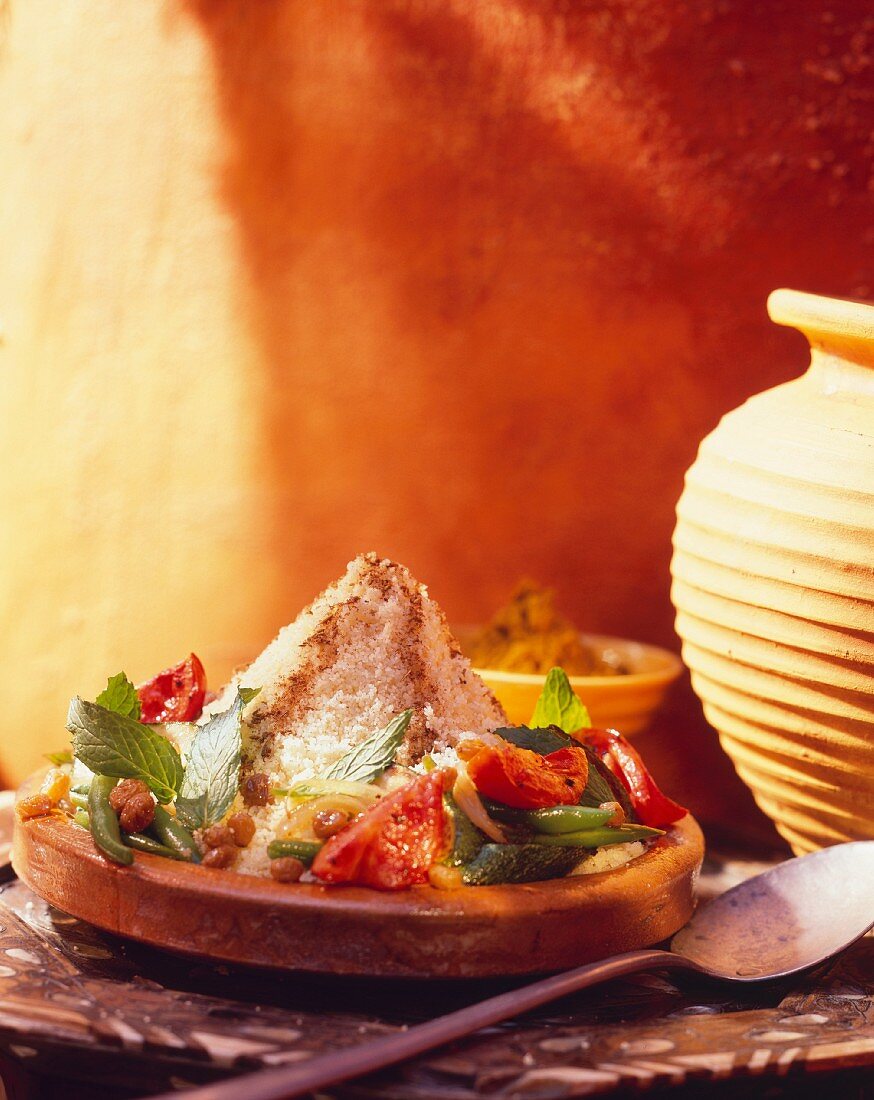 Couscous with vegetables, raisins and mint in a tajine