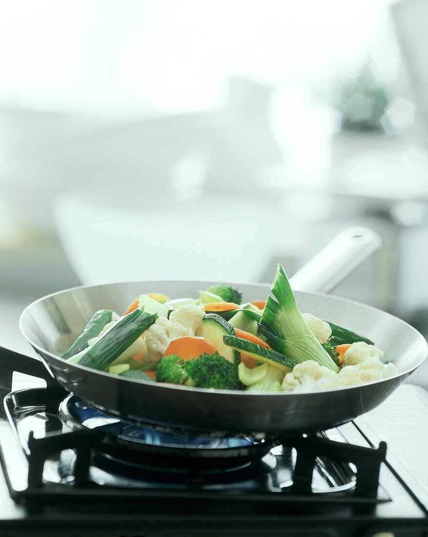 Colourful vegetable stir-fry on gas cooker