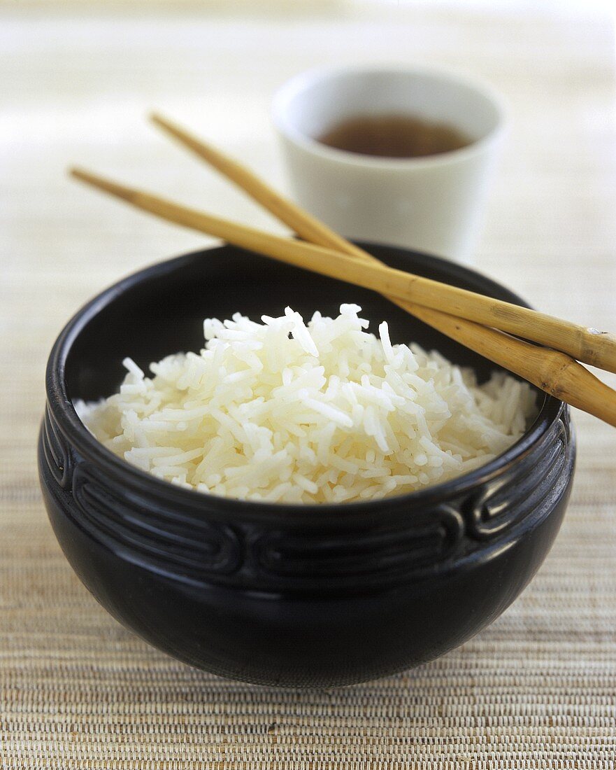 Ein Schälchen gekochter Reis mit Stäbchen
