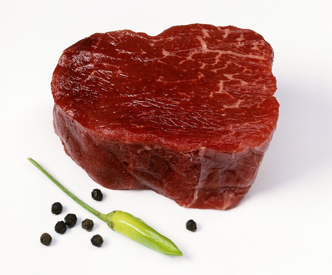 A slice of beef fillet, peppercorns & green chili pepper