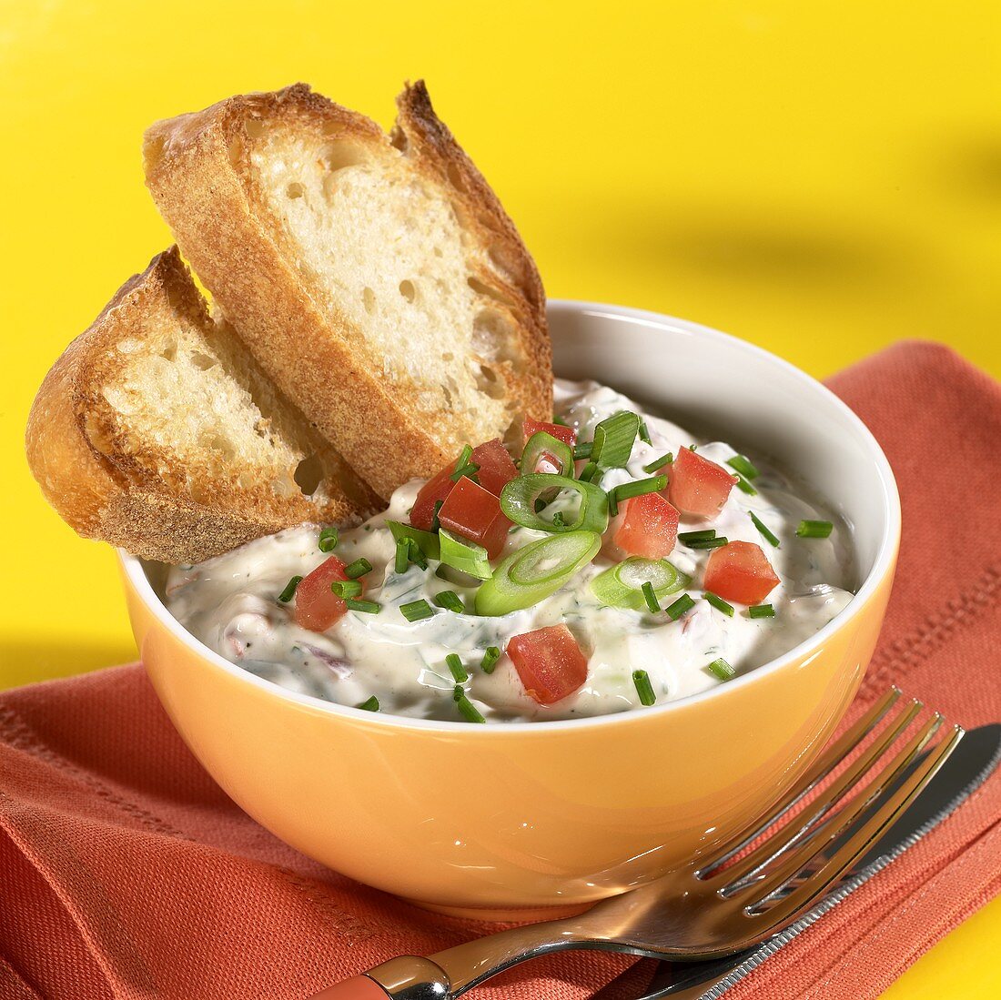 Tomato & spring onion quark with slices of bread in bowl