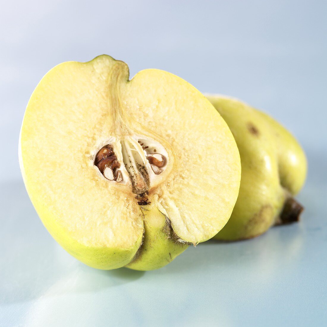 Half a quince in front of a whole quince