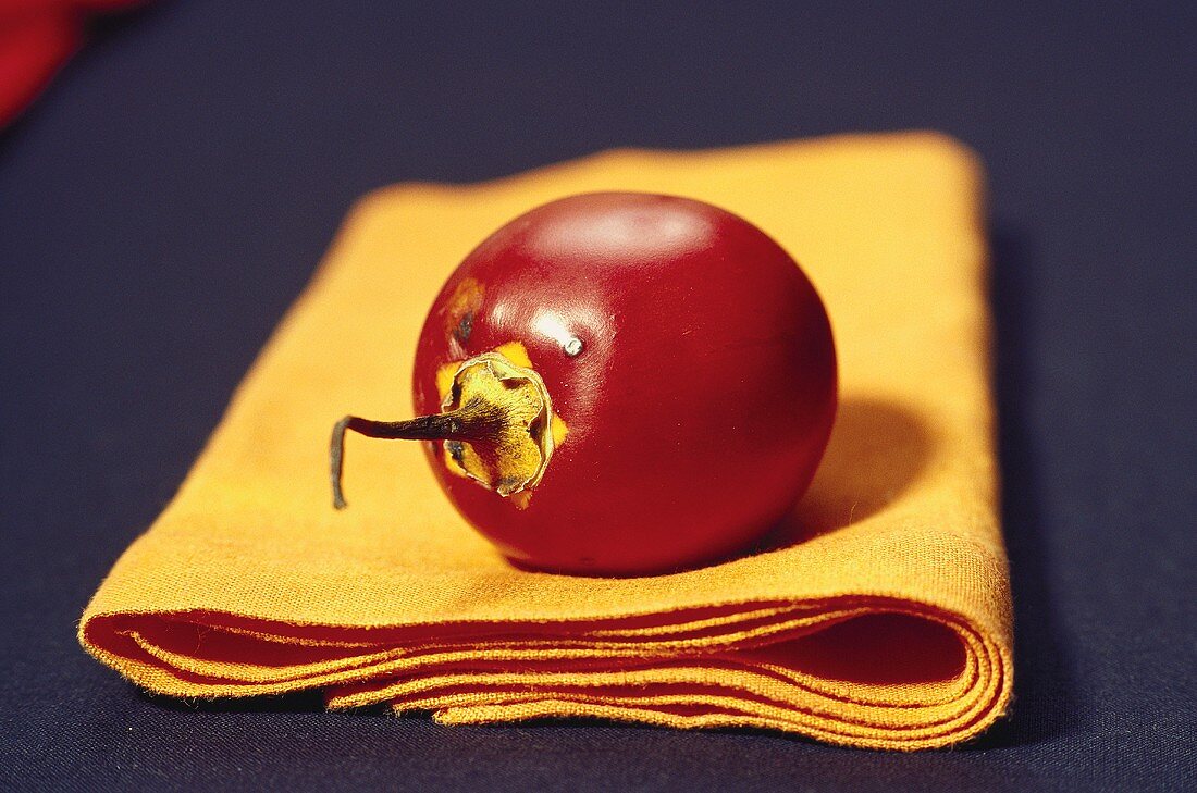 A tamarillo on fabric napkin