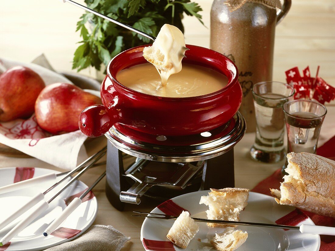 Cheese fondue in a red caquelon (fondue pan)