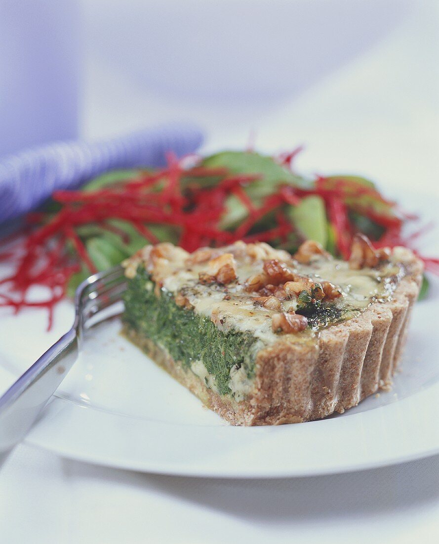 Piece of spinach quiche with cheese and walnuts