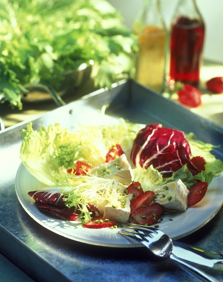 Mixed salad leaves with soft cheese and strawberries