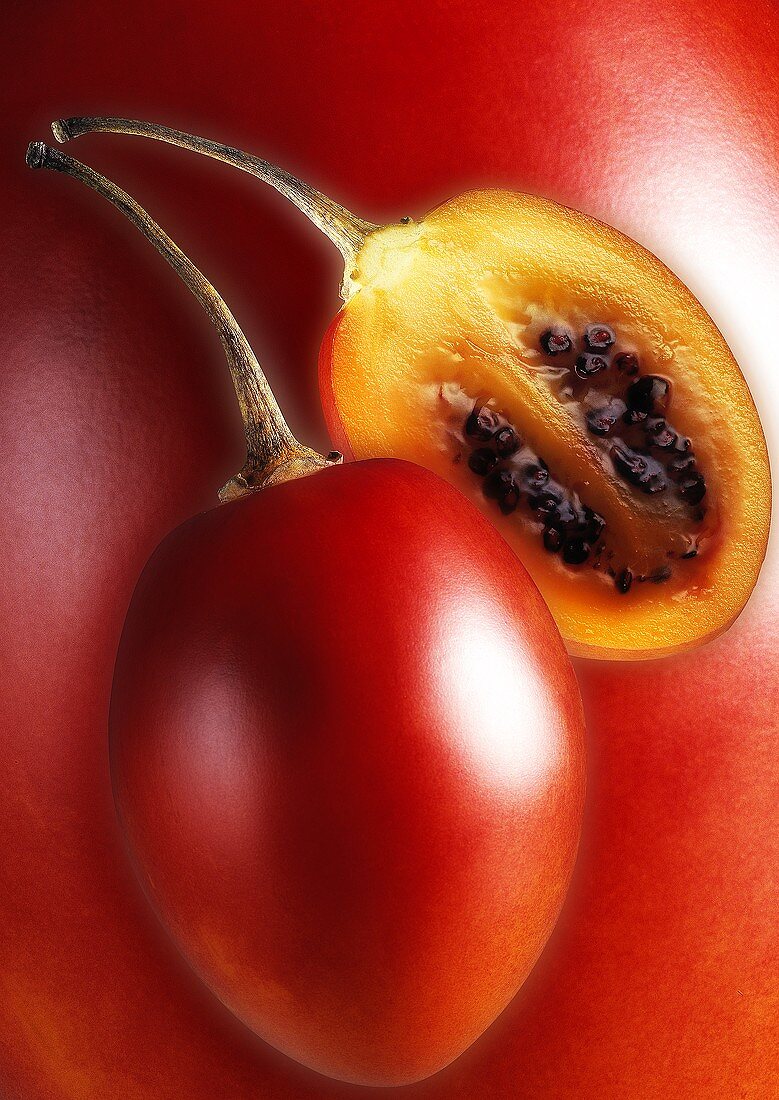 Whole and half tamarillo (tree tomato)
