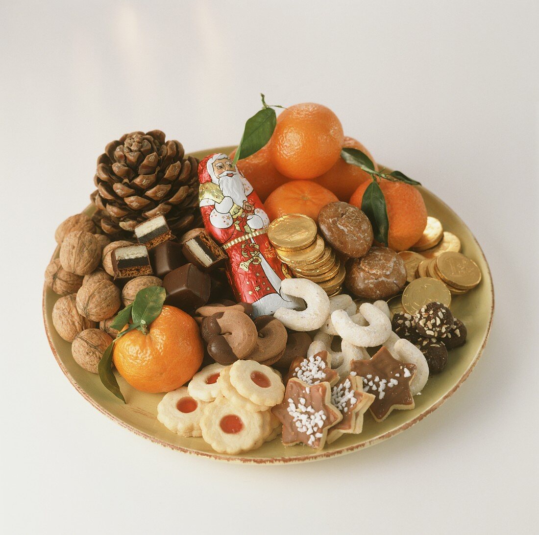 Colourful biscuit plate with mandarins, nuts, chocolate