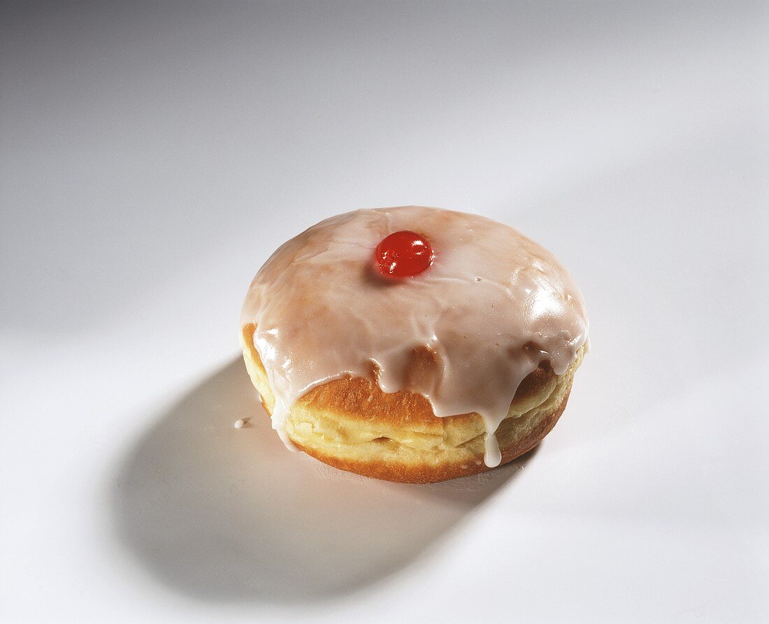 A doughnut with icing and cherry filling