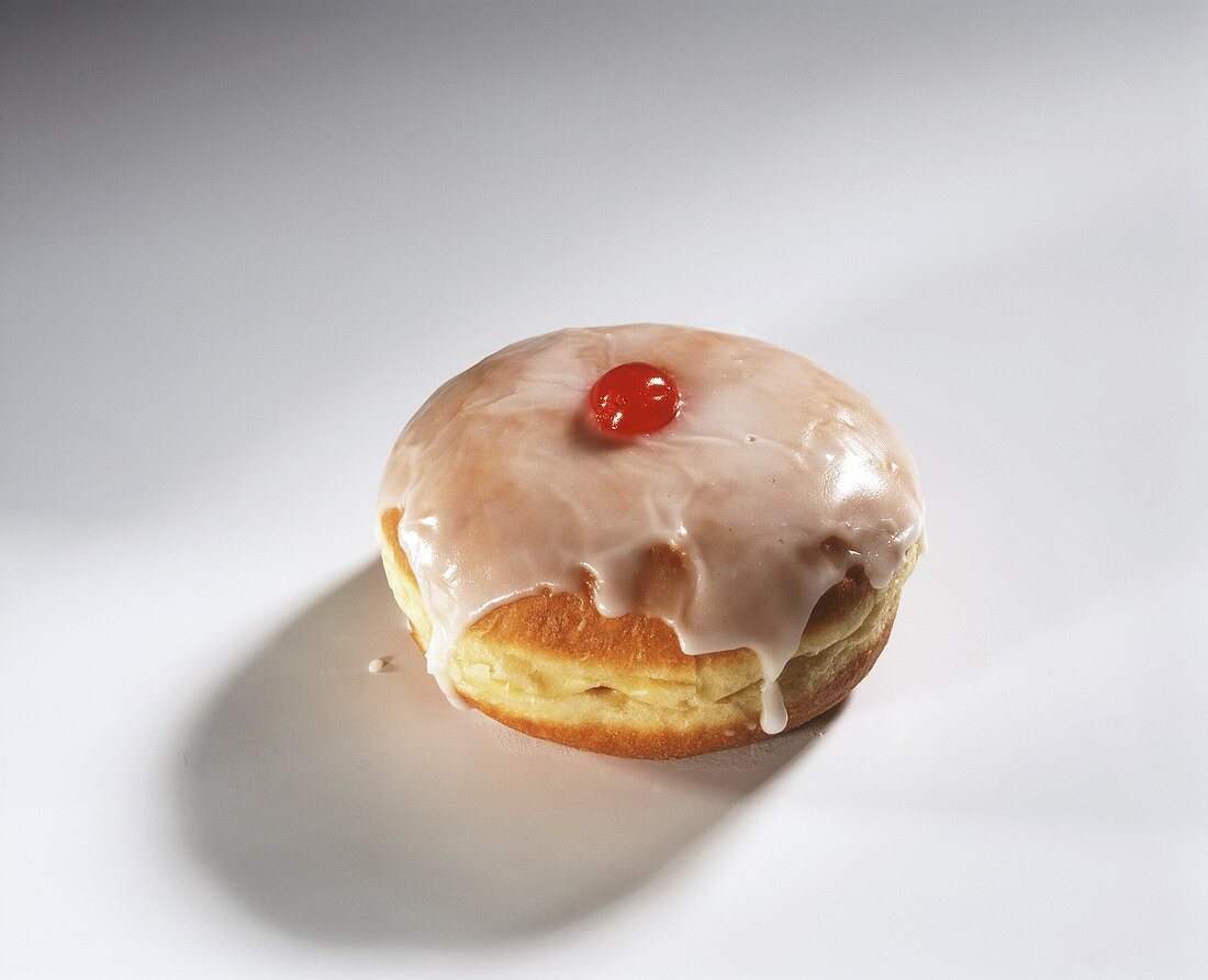 Ein Krapfen mit Zuckerglasur und Kirschfüllung