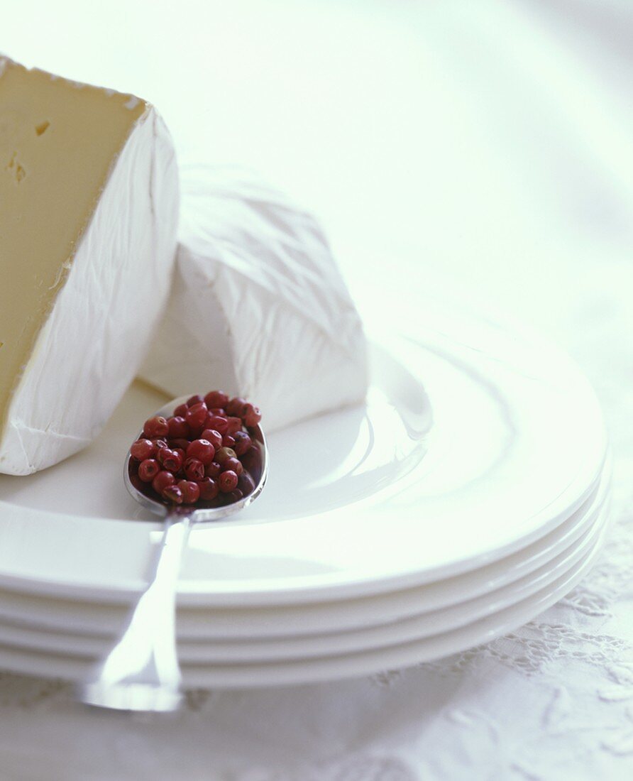 A halved Camembert with a teaspoonful of cranberries