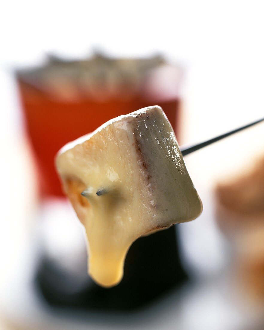 Cheese fondue with bread cube on fondue fork