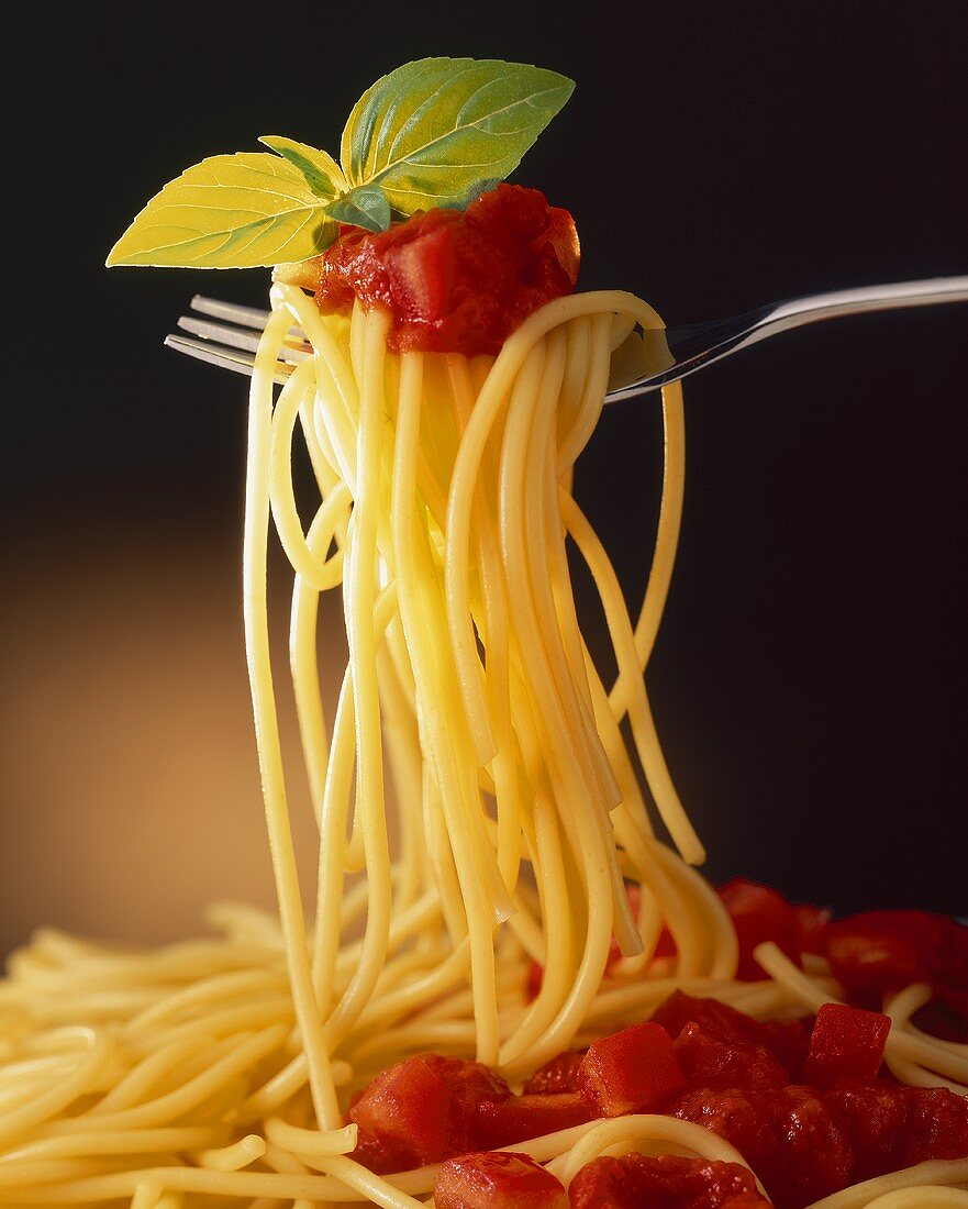 Spaghetti mit Tomatensauce und Basilikum auf Gabel