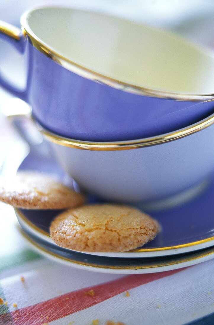 Leere Kaffeetassen und zwei Plätzchen