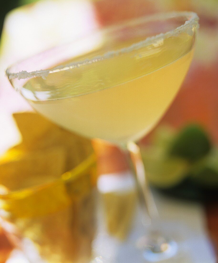 Margarita in cocktail glass, taco chips behind