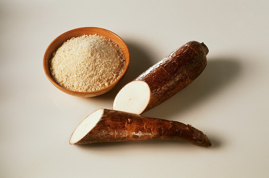 Halved manioc root, bowl of manioc flour beside it