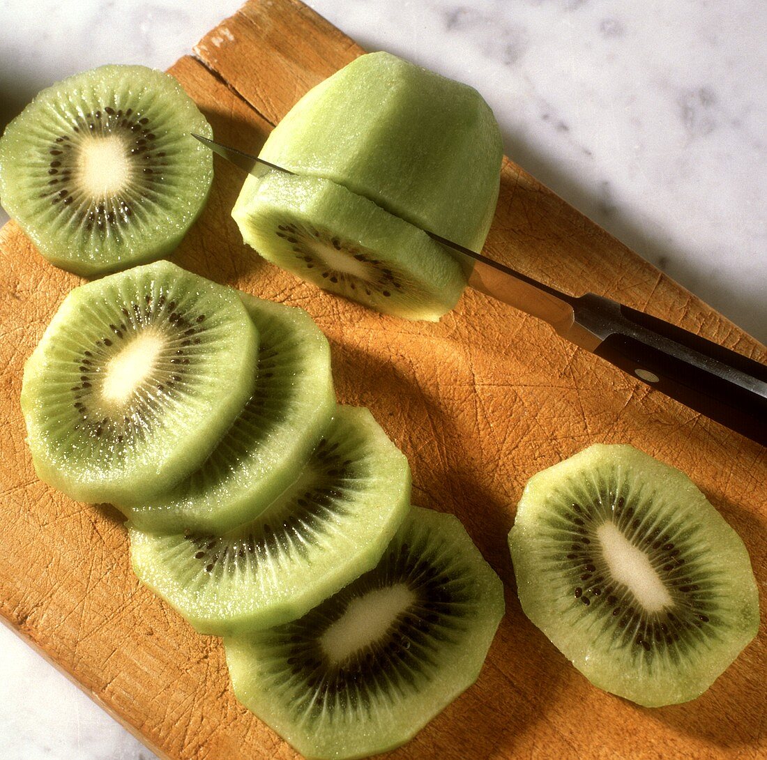 Slicing peeled kiwi fruit