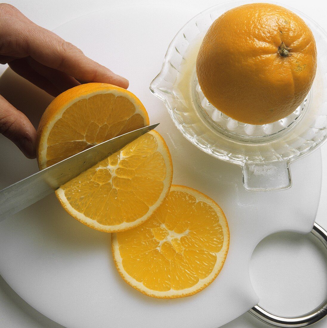 Squeezing orange half and cutting orange into slices
