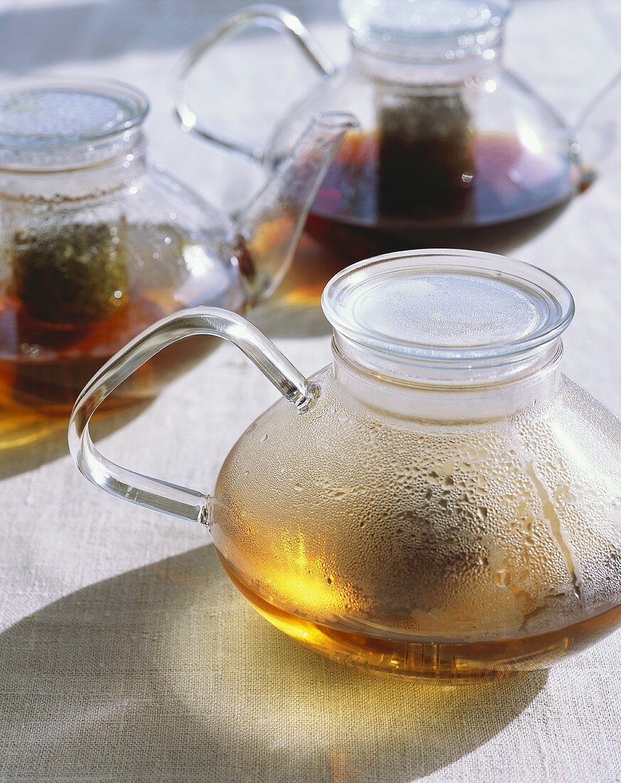 Drei Glasteekannen mit Tee (bereits halb leer)