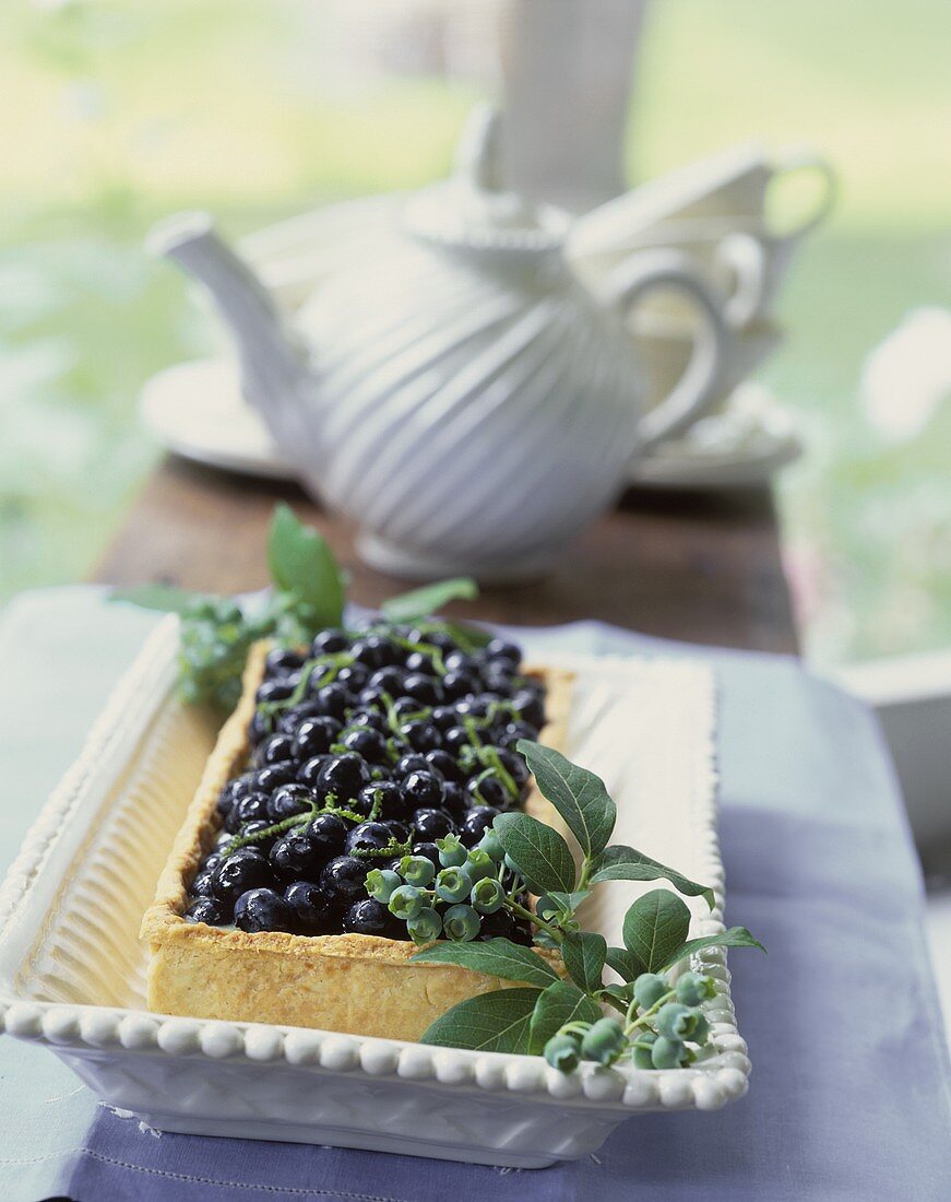 Tart with fresh blueberries; coffee pot in background