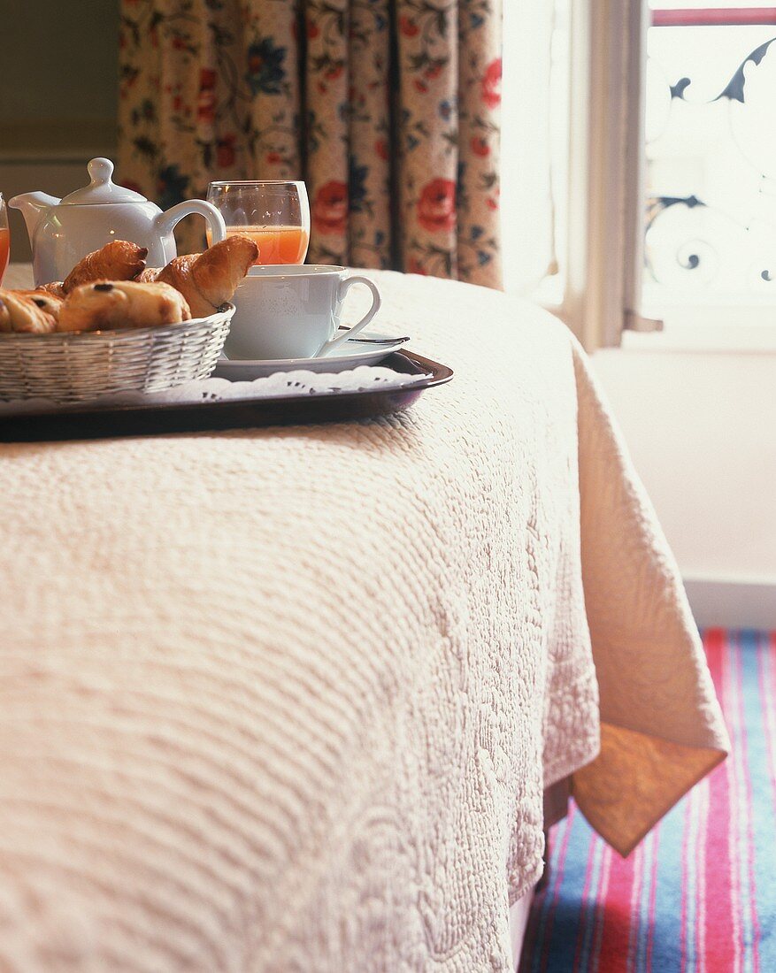 Breakfast tray on edge of bed in a Paris hotel