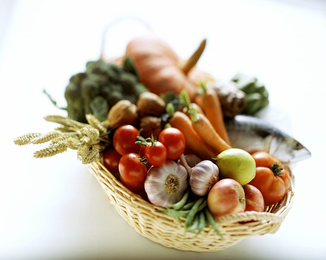 Ein Korb mit Makrele, Obst, Gemüsen und Nüssen