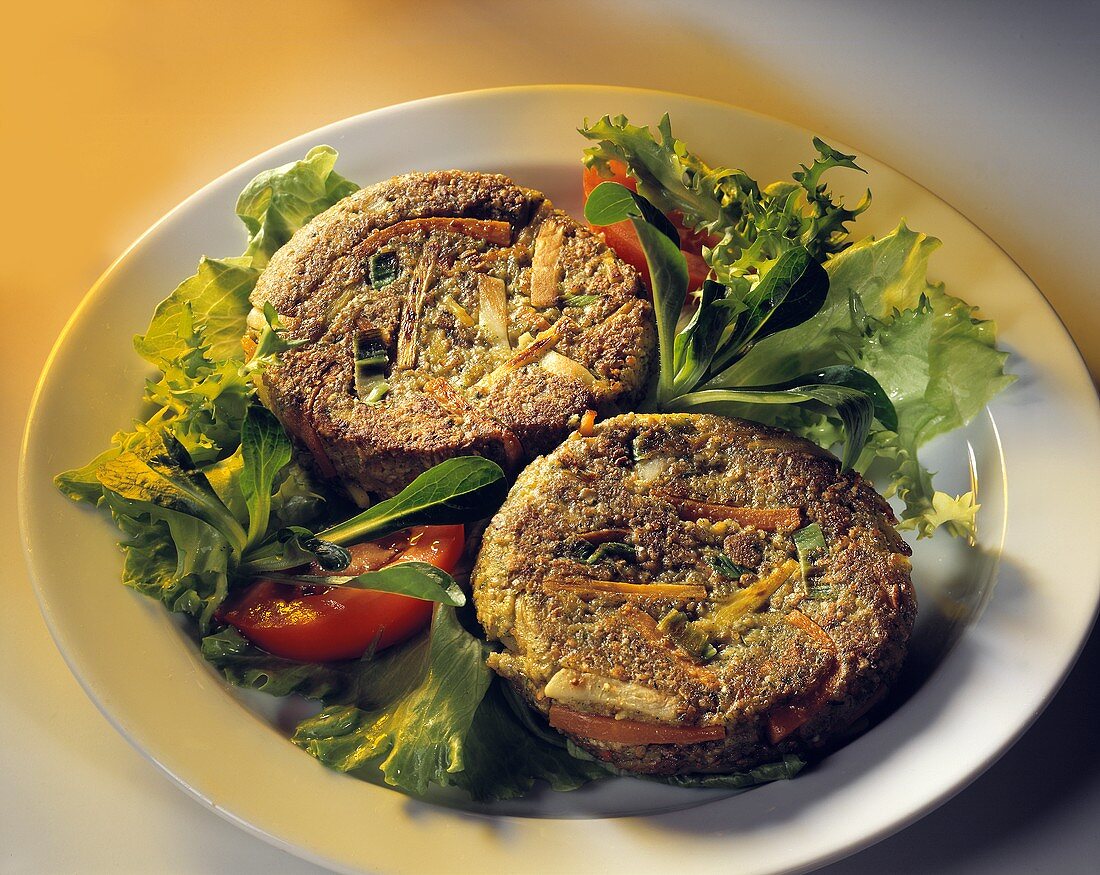 Two vegetable burgers on mixed salad