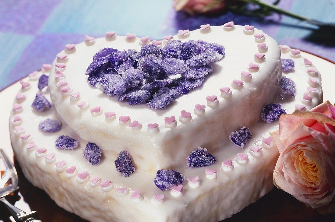 Two-tiered heart-shaped cake with candied violets