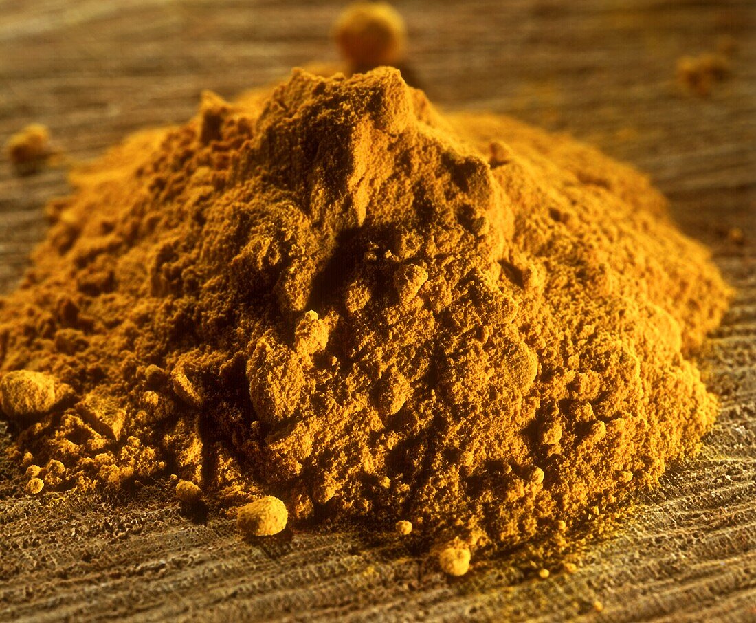 Ground turmeric on a brown background