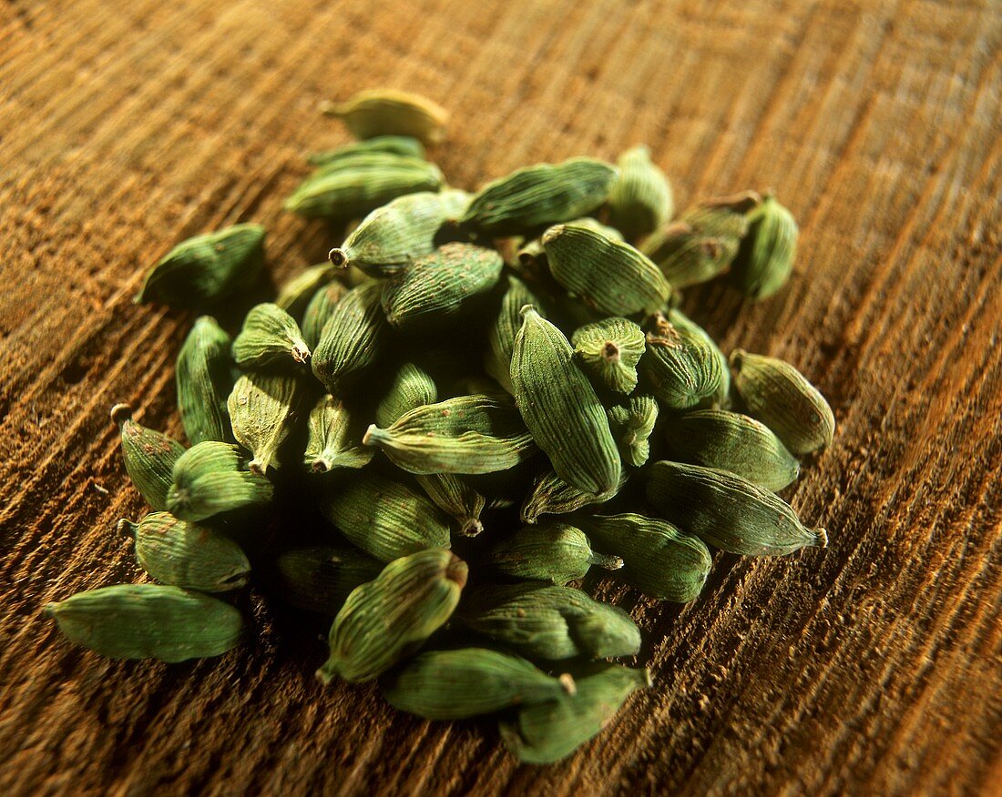 Green cardamom capsules on a brown background