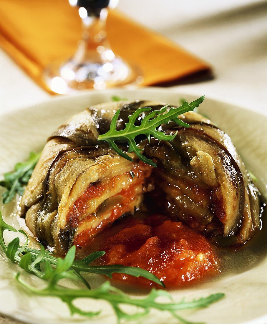 Aubergine charlotte with tomato sauce, a piece cut