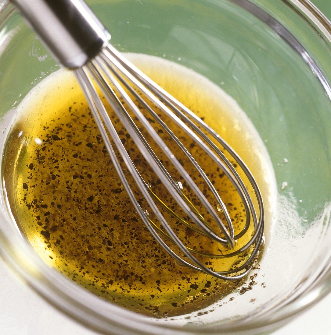 Making salad dressing with vinegar, oil and pepper