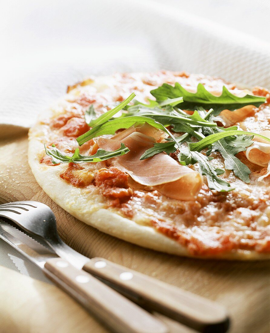 Pizza mit Parmaschinken und Rucola