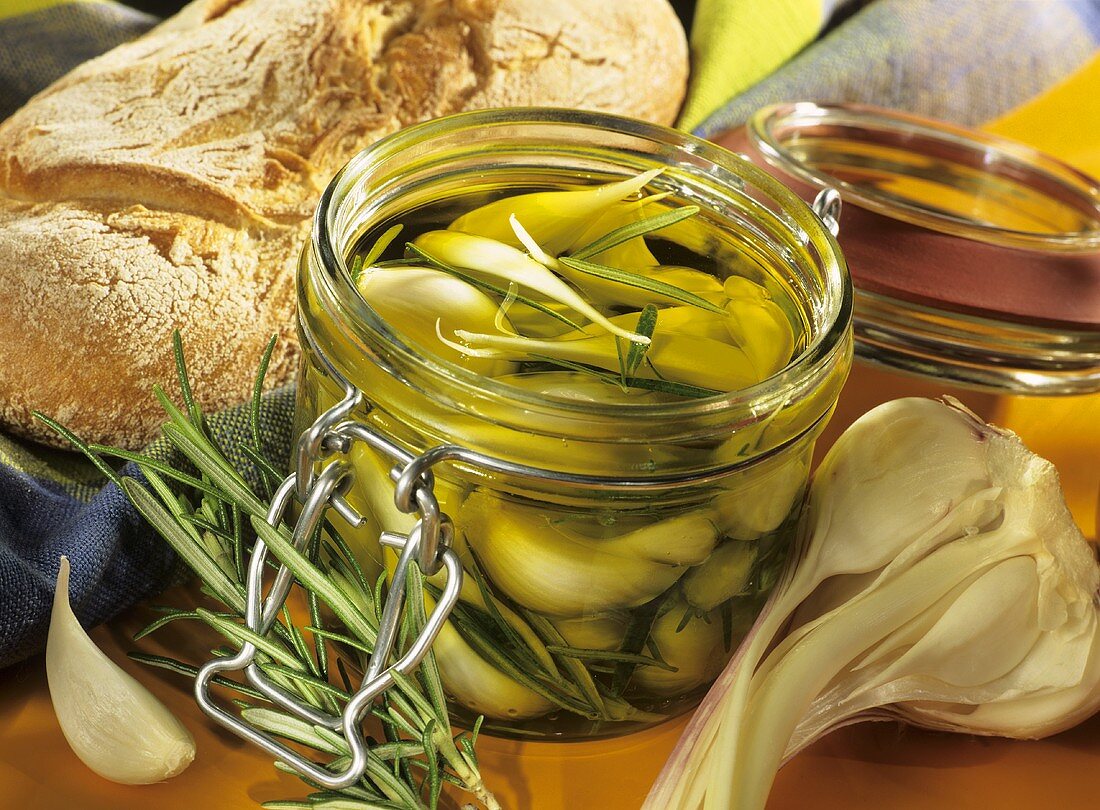 In Olivenöl eingelegter Knoblauch mit Rosmarin im Glas